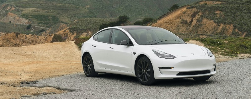 A Tesla Model 3 on a hillside